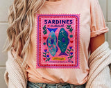 "Sardines Purple Stamp" design on a peach unisex t-shirt