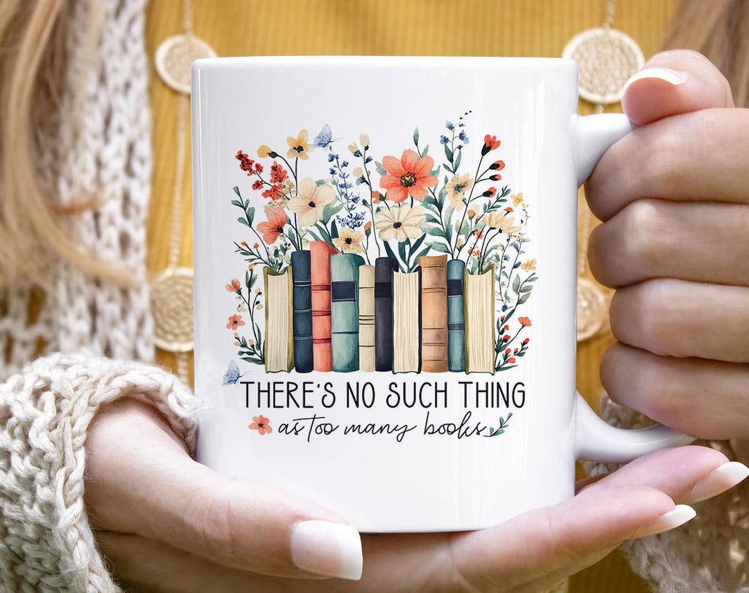 "There's No Such As Too Many Books" design on a white ceramic coffee mug