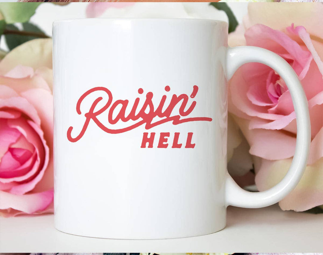 "Raisin Hell" design on a white ceramic coffee mug