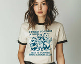 "I Tried To Form A Gang Book Club" design on a natural ringer t-shirt with black contrast trim