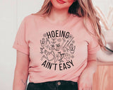 "Hoeing Ain't Easy" design on a peach unisex t-shirt