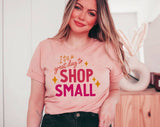 "It's A Great Day To Shop Small" design on a peach unisex t-shirt