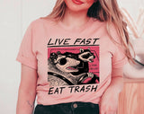 "Live Fast Eat Trash Raccoon" design on a peach unisex t-shirt