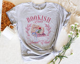 "Bookish Lovers Social Club Coquette" design on a heather gray unisex t-shirt