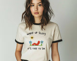 "Wake Up Sluts, It's Time To Sin" design on a natural ringer t-shirt with black contrast trim