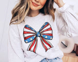 "4th of July Coquette Bow American Flag" design on an ash gray unisex crewneck sweatshirt