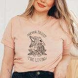 "Never Trust The Living" design on a unisex t-shirt