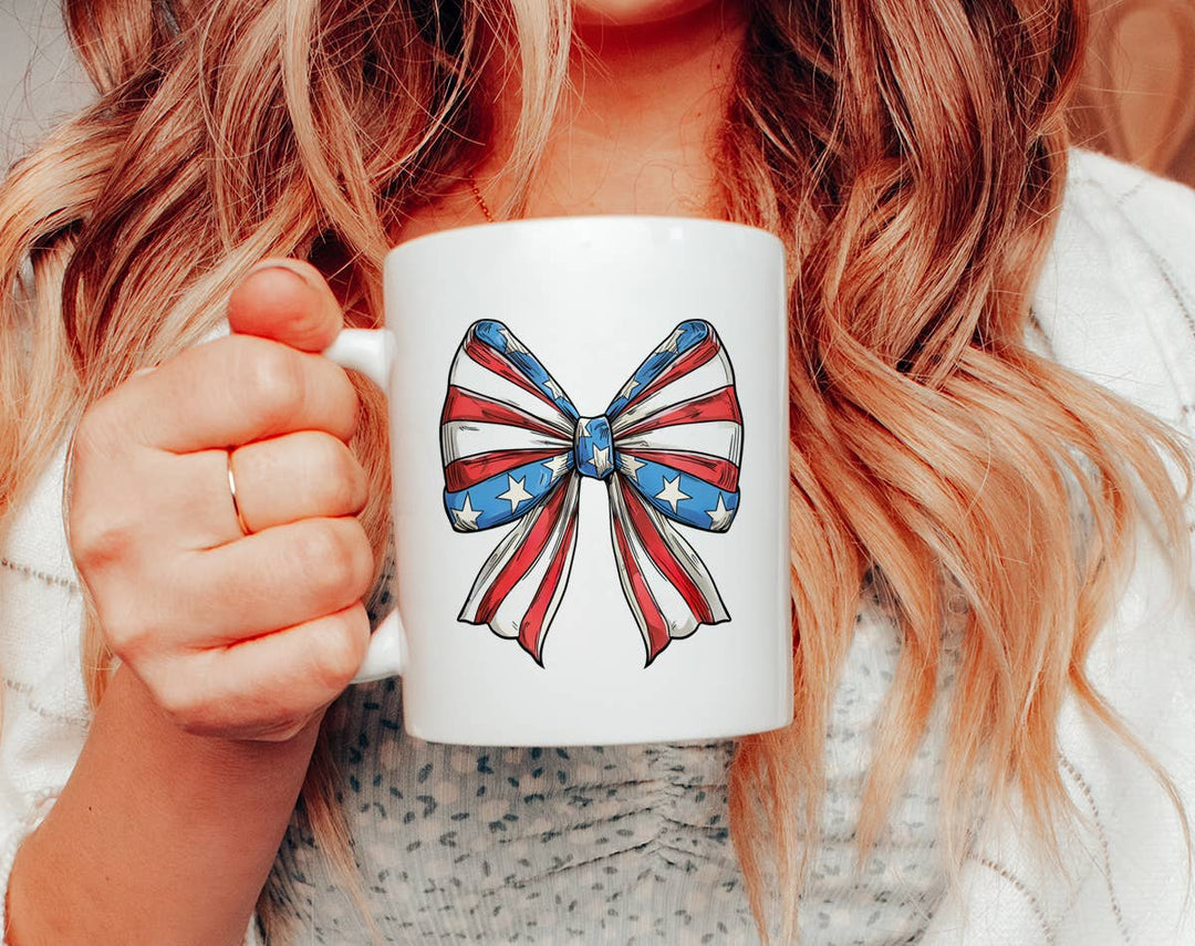 "4th of July Coquette Bow American Flag" design on a white ceramic coffee mug