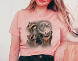 "3 Raccoons Howling At The Moon" design on a peach unisex t-shirt