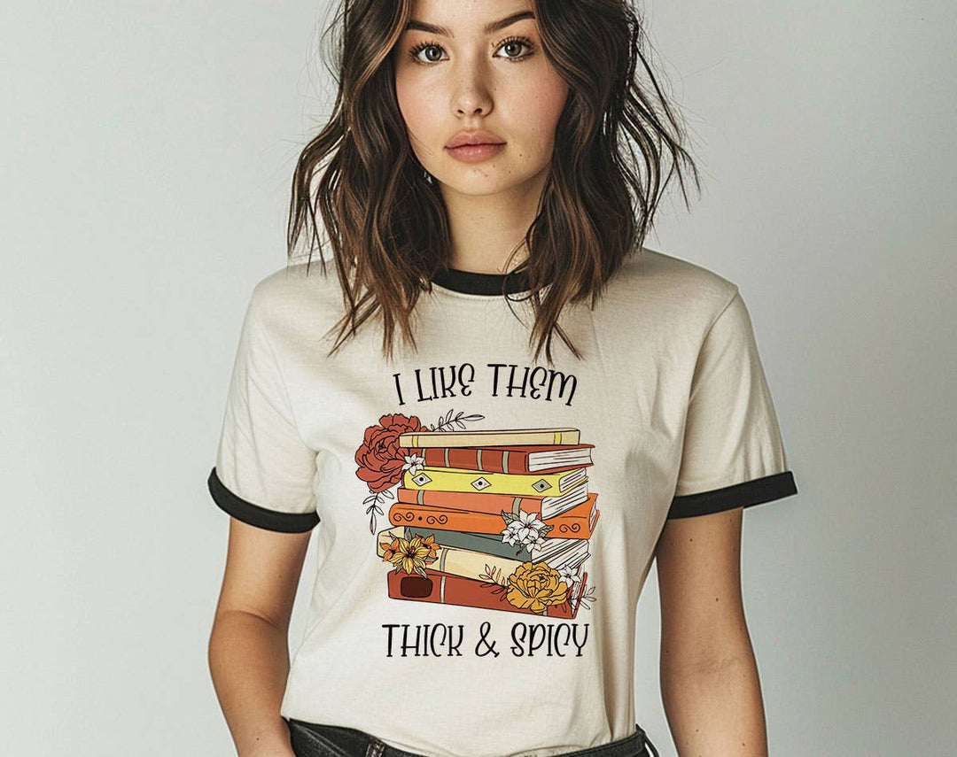 "I Like Them Thick & Spicy Romance Book" design on a natural ringer t-shirt with black contrast trim
