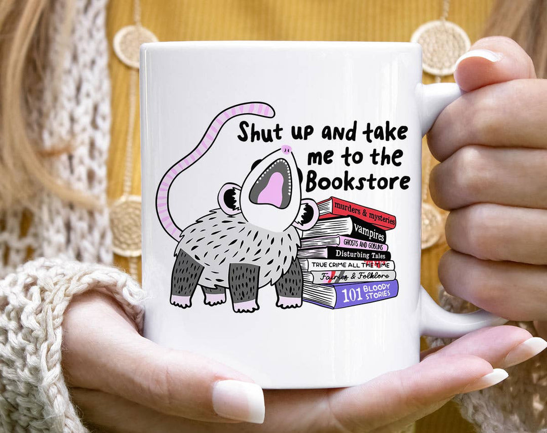 "Shut Up And Take Me To The Bookstore" design on a white ceramic coffee mug