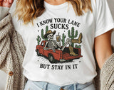 "I Know Your Lane Sucks Skeleton" design on a white unisex t-shirt