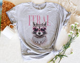 "Feral Vogue Raccoon" design on a heather gray unisex t-shirt