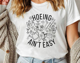 "Hoeing Ain't Easy" design on a white unisex t-shirt