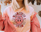 "Valentine Vibes Smiley Peace" design on a peach unisex t-shirt