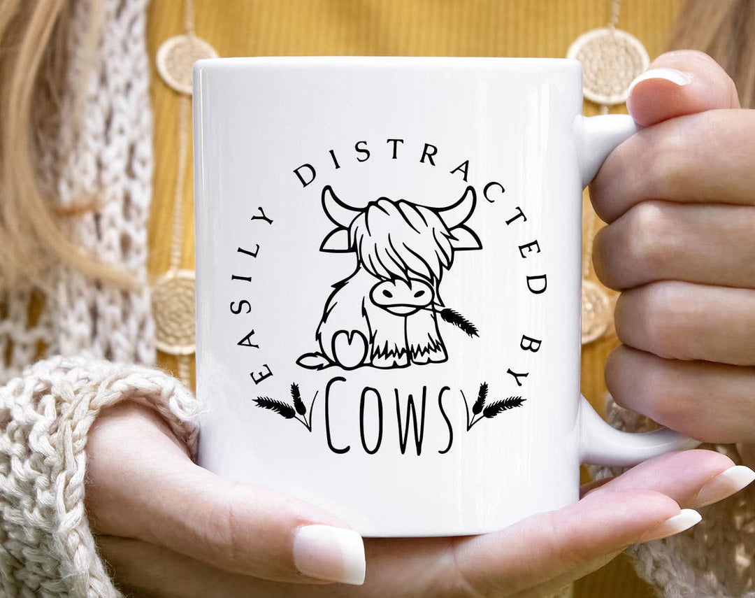 "Easily Distracted By Cows" design on a white ceramic coffee mug