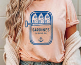 "Sardines Blue Tin" design on a peach unisex t-shirt