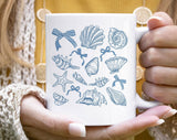 "Seashell Blue Beach Collage" design on a white ceramic coffee mug