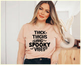 "Thick Thighs, Spooky Vibes" design on a peach unisex t-shirt