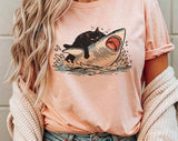 "Cat Riding Shark" design on a peach unisex t-shirt
