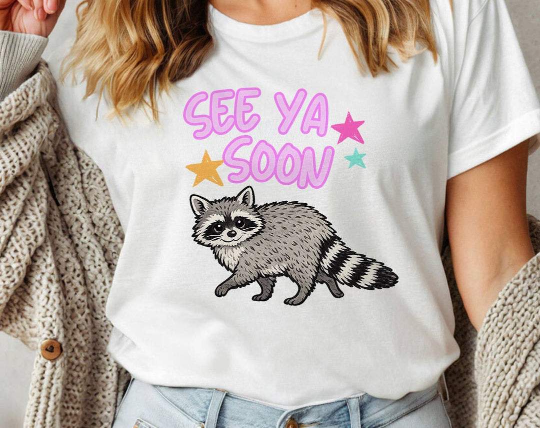 "See You Soon Raccoon" design on a white unisex t-shirt