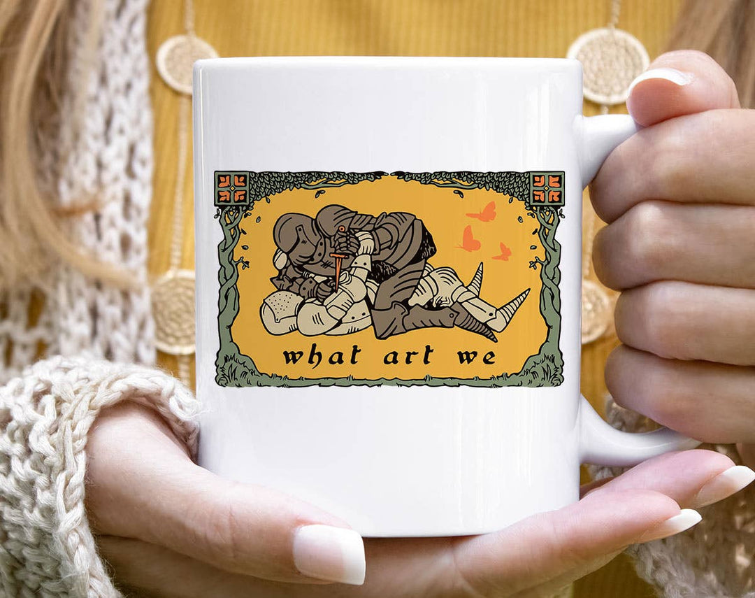 "What Art We" design on a white ceramic coffee mug