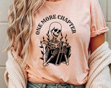 "One More Chapter Skeleton" design on a peach unisex t-shirt