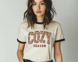 "Cozy Season Fall Leaves" design on a natural ringer t-shirt with black contrast trim