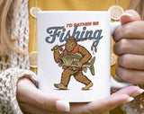 "I'd Rather Be Fishing Bigfoot" design on a white ceramic coffee mug