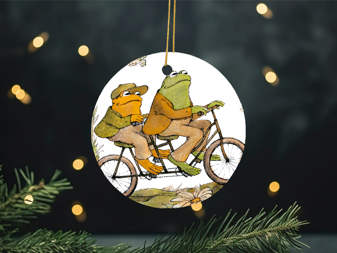 "Frog And Toad Cottagecore Reading" design on a 2.5 inch round ceramic Christmas ornament