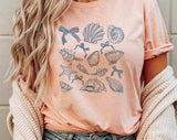 "Seashell Blue Beach Collage" design on a peach unisex t-shirt