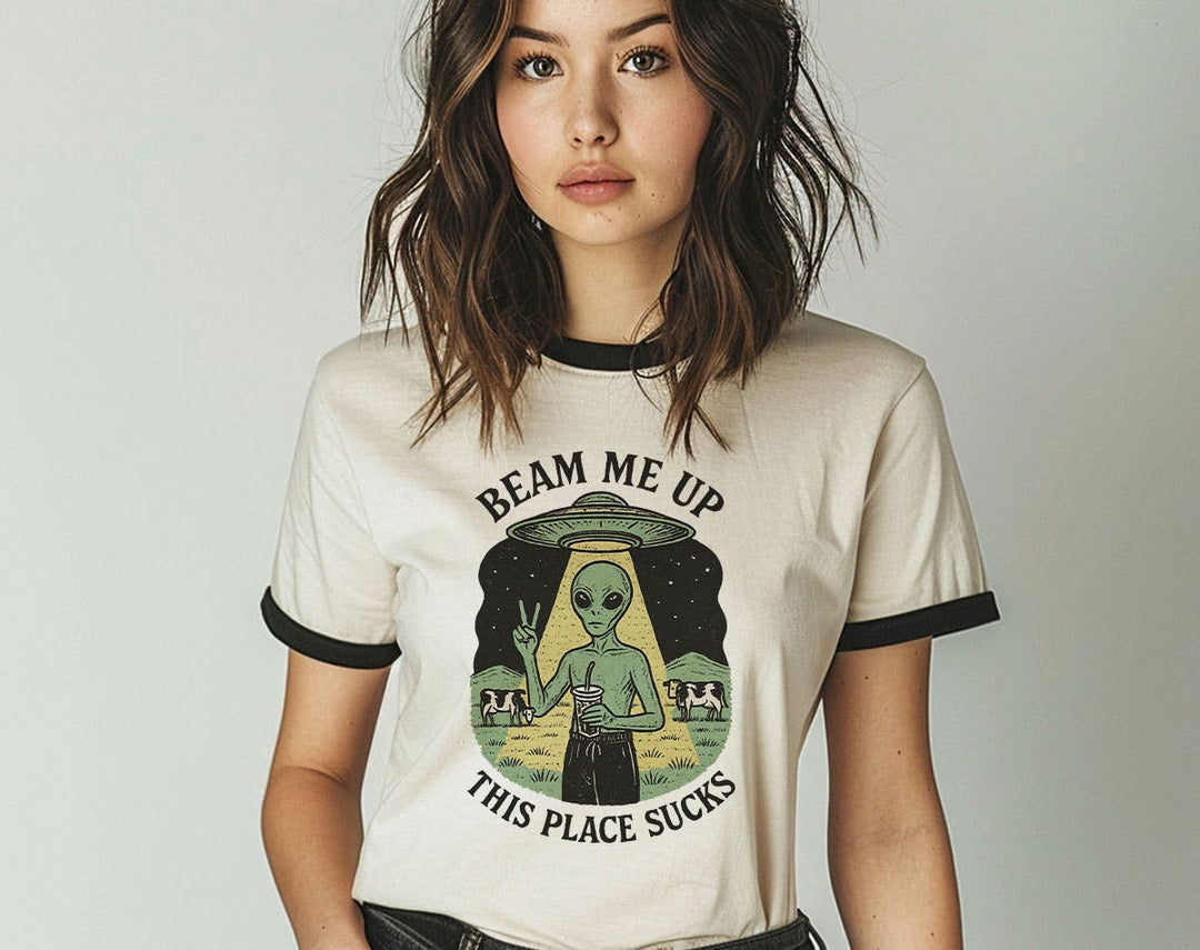 "Beam Me Up, This Place Sucks Alien" design on a natural ringer t-shirt with black contrast trim