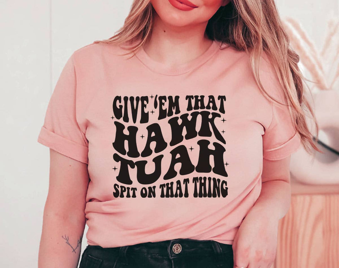 "Give 'Em That Hawk Tuah" design on a peach unisex t-shirt
