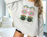 "Lucky Vibes Gold Rainbow" design on an ash gray unisex crewneck sweatshirt
