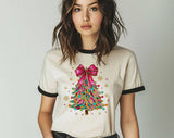 "Coquette Christmas Tree Pink Bow" design on a natural ringer t-shirt with black contrast trim