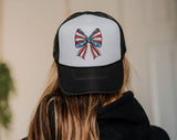 "Coquette Bow American Flag" design on a mesh-back snapback trucker hat