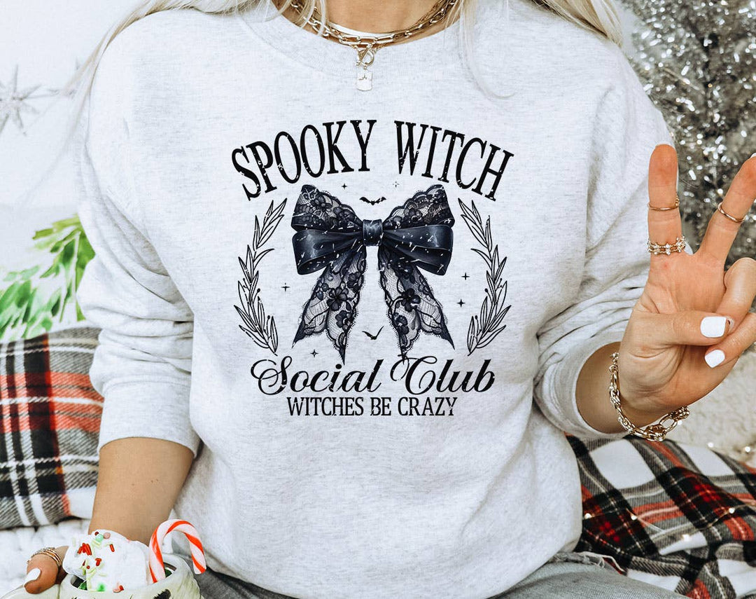 "Spooky Witch Social Club" design on an ash gray unisex crewneck sweatshirt