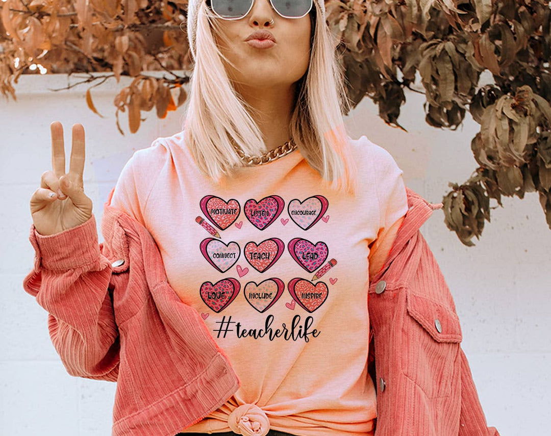 "Teacher Life Hearts" design on a peach unisex t-shirt