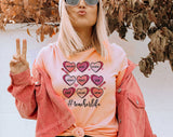 "Teacher Life Hearts" design on a peach unisex t-shirt