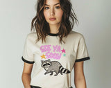 "See You Soon Raccoon" design on a natural ringer t-shirt with black contrast trim