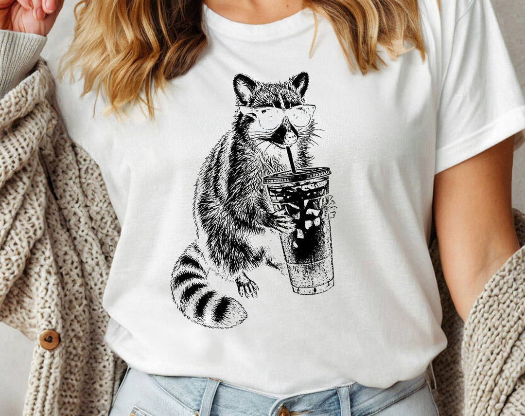 "Raccoon Drinking Iced Coffee" design on a white unisex t-shirt