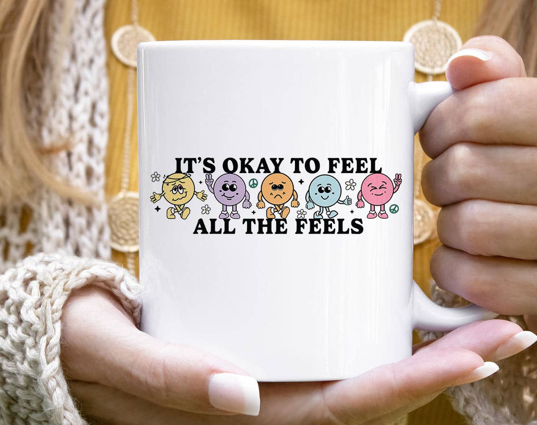 "It's Okay To Feel All The Feels" design on a white ceramic coffee mug