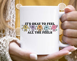 "It's Okay To Feel All The Feels" design on a white ceramic coffee mug