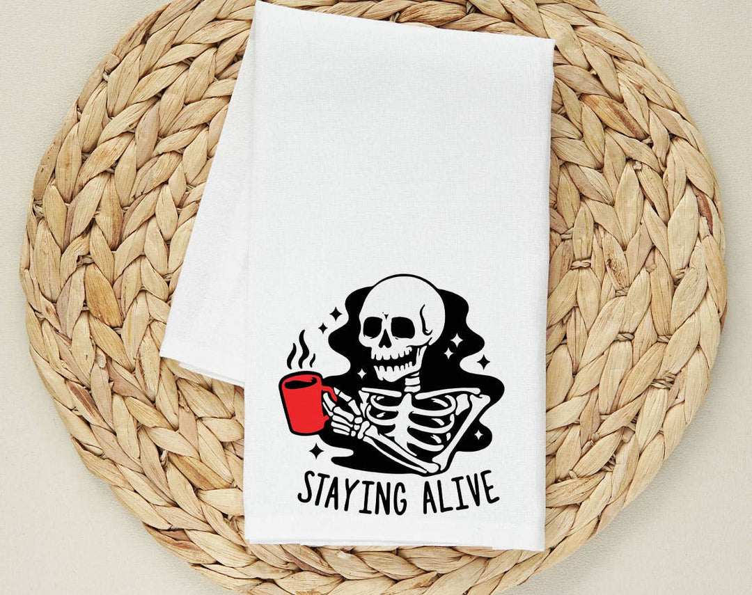 "Staying Alive Coffee Skeleton" design on a white 28 x 28 inch flour sack tea towel