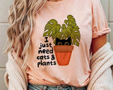 "I Just Need Cats And Plants" design on a peach unisex t-shirt