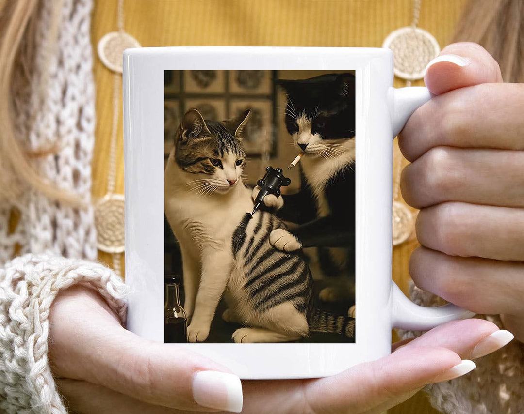 "Cat Getting Tattoo" design on a white ceramic coffee mug