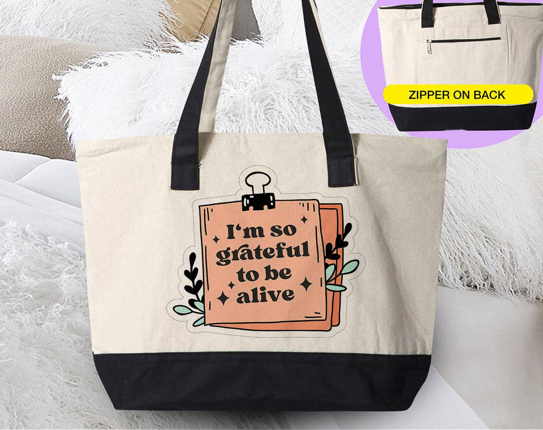 "I'm So Grateful To Be Alive" design on a natural canvas zippered tote bag