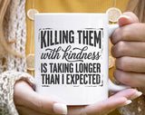 "Killing Them With Kindness" design on a white ceramic coffee mug