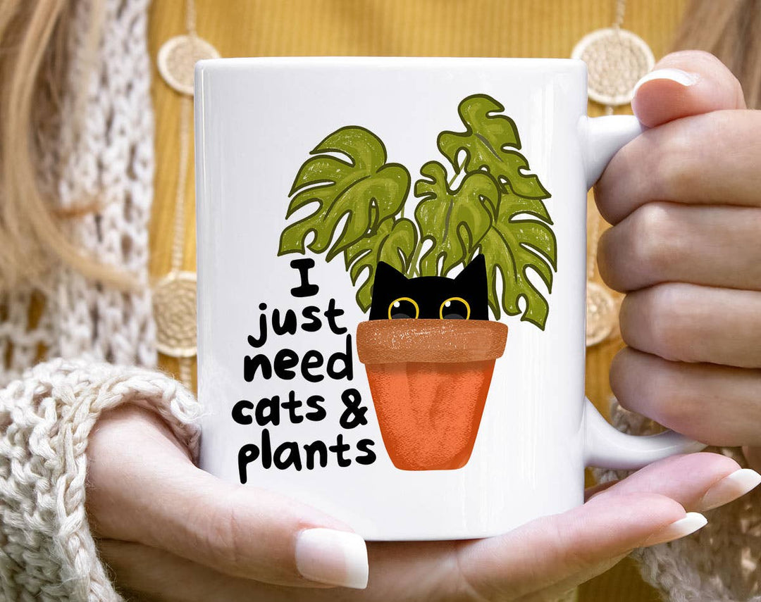 "I Just Need Cats And Plants" design on a white ceramic coffee mug