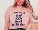 "I Survived Today's Tummy Ache" design on a peach unisex t-shirt